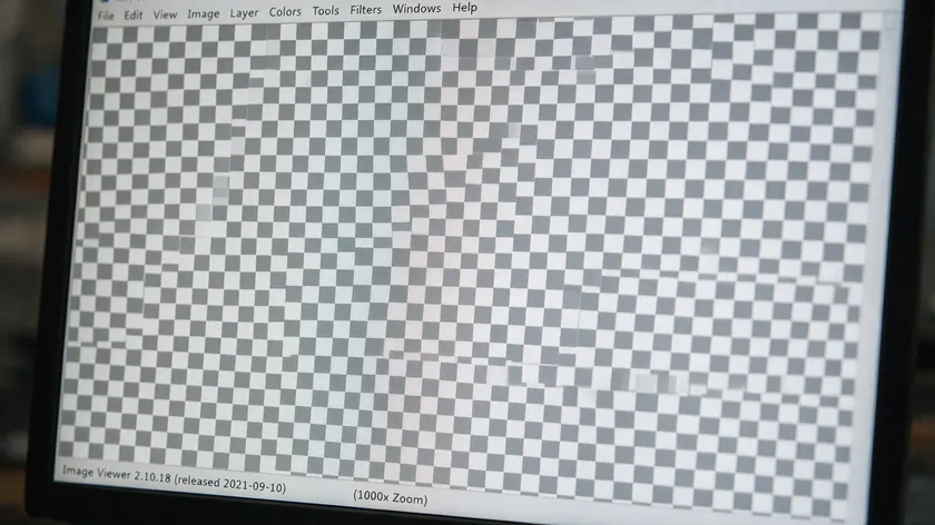 Extreme close-up of checkerboard pixels on a monitor, showing how to remove checkered background from PNG files by first confirming the grid is baked in