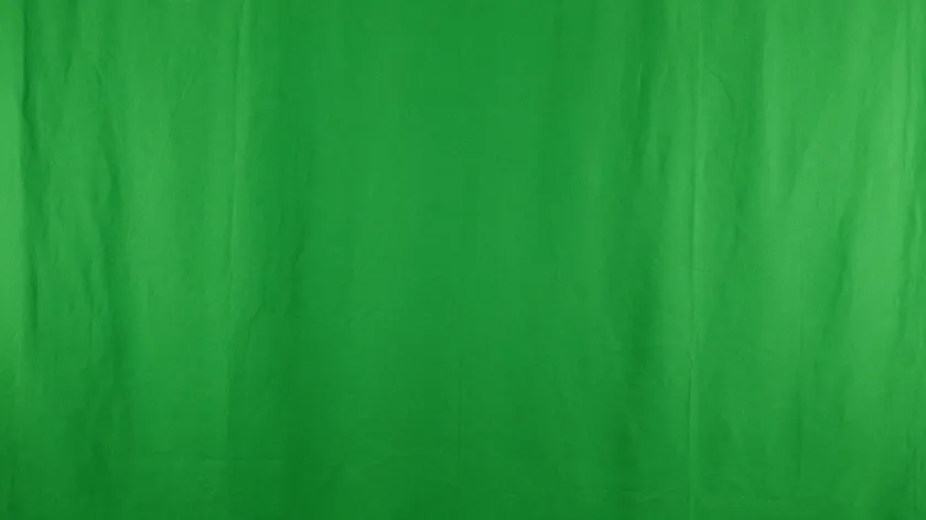 Close-up of an evenly lit, solid green screen fabric backdrop used for chroma key photography.