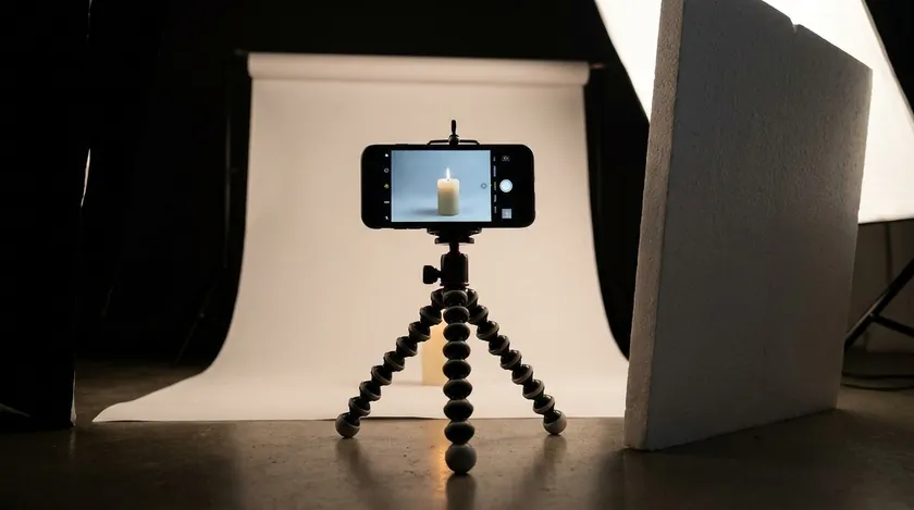 Phone on a tripod facing a product on a seamless white backdrop for marketplace-ready ecommerce product photography